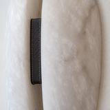 Close-up of a textured beige fabric with a black leather tag.