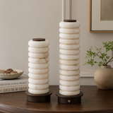 Two decorative lamps with stacked circular designs on a wooden table.