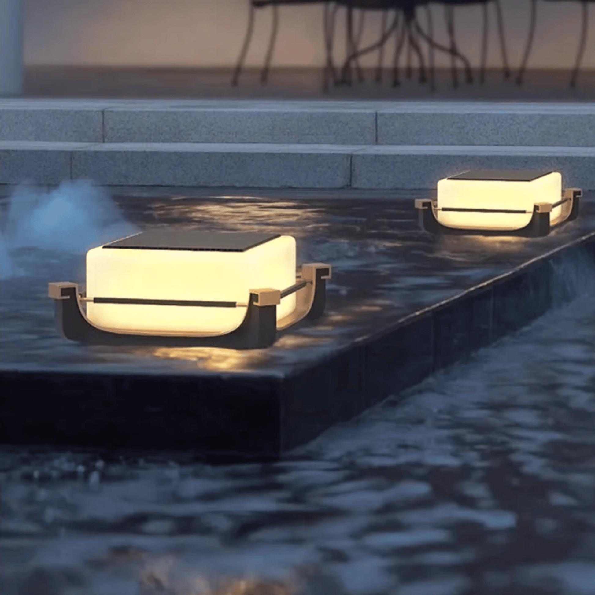 Two modern outdoor lights on a stone ledge near water