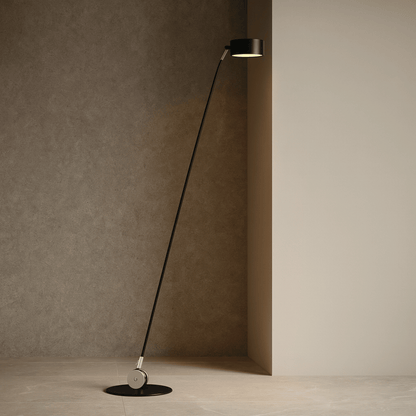 Modern floor lamp with long black cable against a neutral wall.