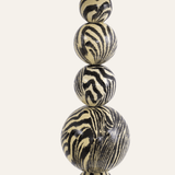 Stack of zebra-striped ceramic beads on a white background