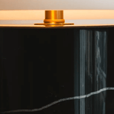 Black cylindrical object with a gold top on a light background