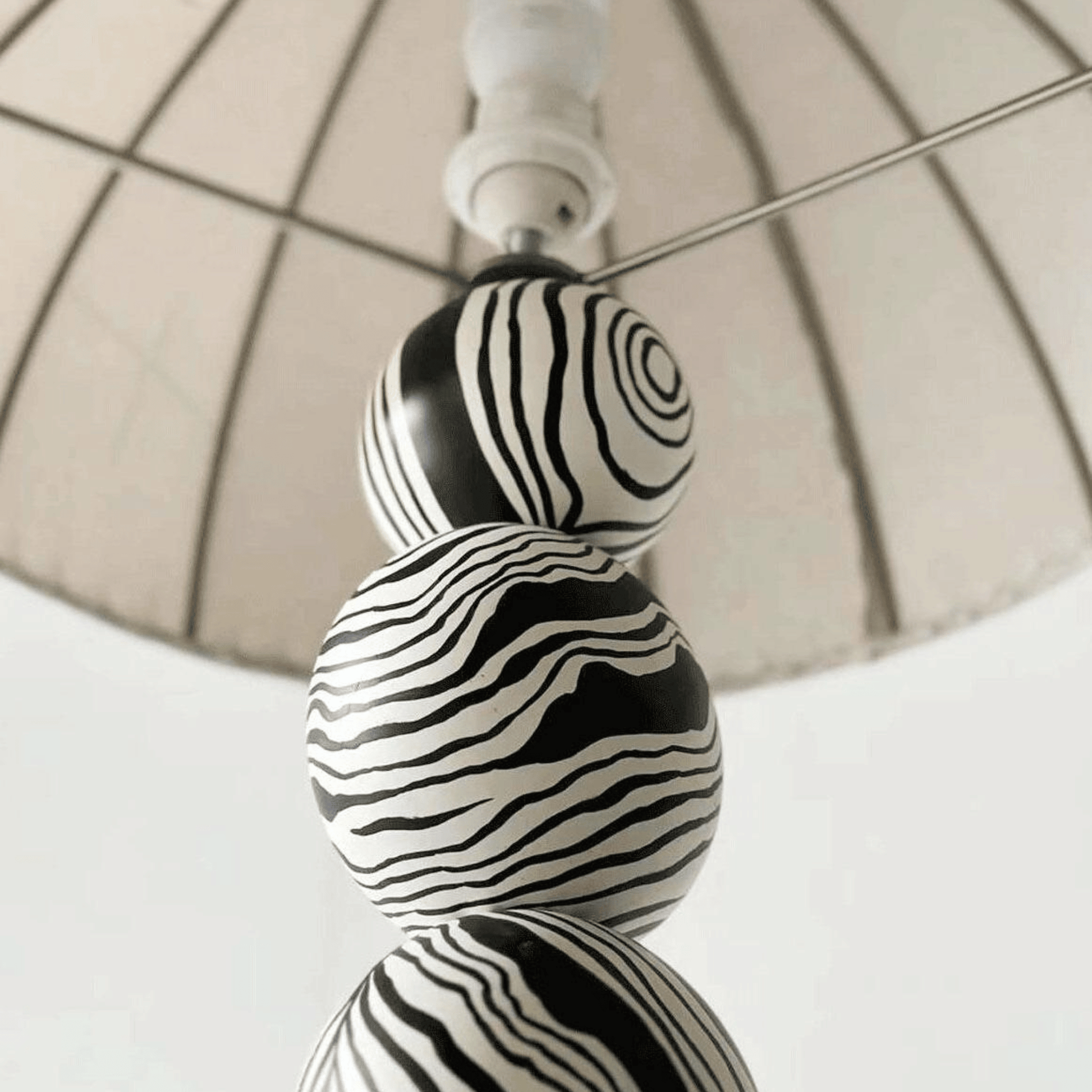 Decorative lamp with black and white striped design on a neutral background