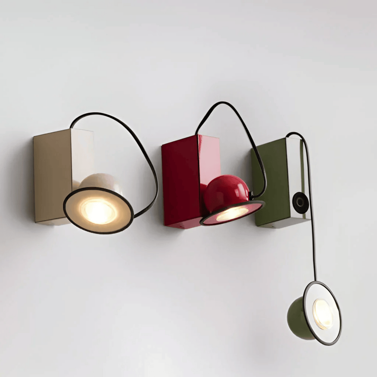 Modern wall-mounted light fixture with three different colored lights on a white background