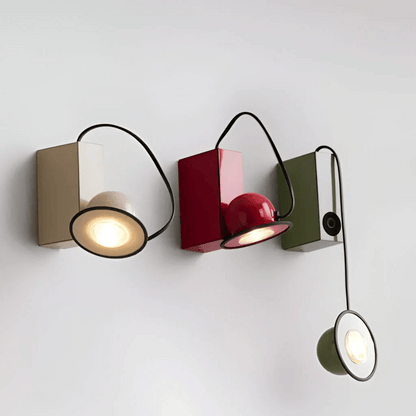 Modern wall-mounted light fixture with three different colored lights on a white background