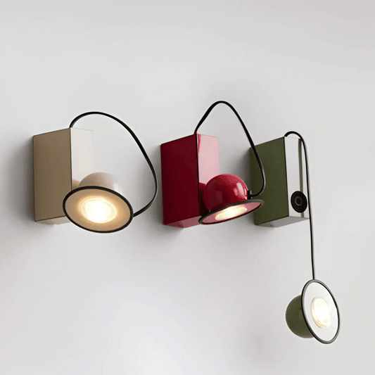 Modern wall-mounted light fixture with three different colored lights on a white background