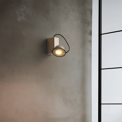 Wall-mounted light fixture on a textured wall with a window in the background