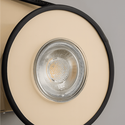 Close-up of a round light fixture with beige and black design.