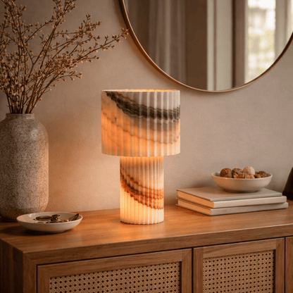 Decorative lamp on a wooden sideboard with a vase and books in the background