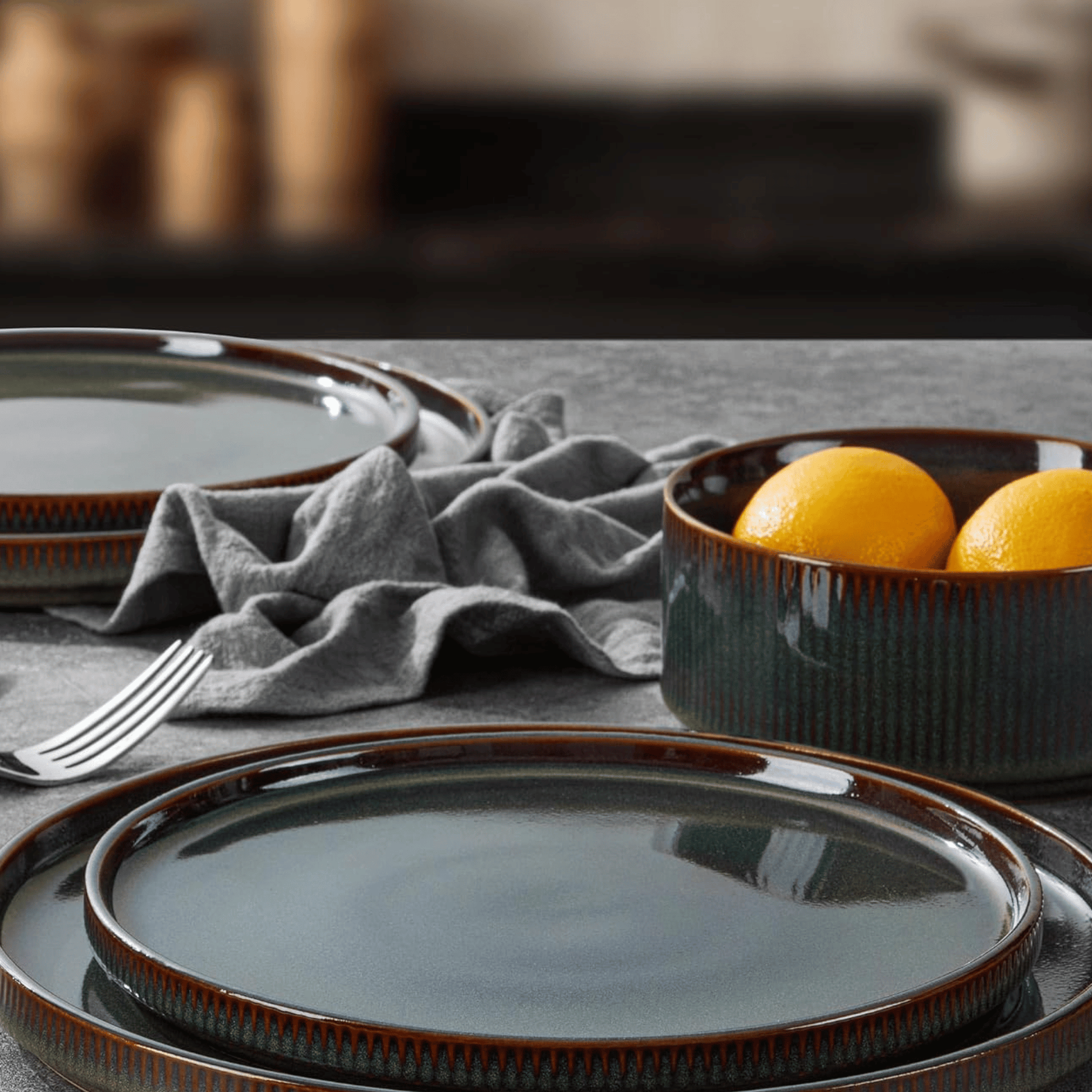 Ceramic plates and bowl with lemons on a table