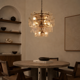 Modern chandelier hanging above a dining table in a dimly lit room.