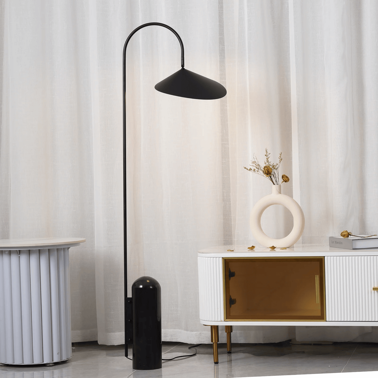 Black floor lamp in a room with white curtains and a white cabinet.