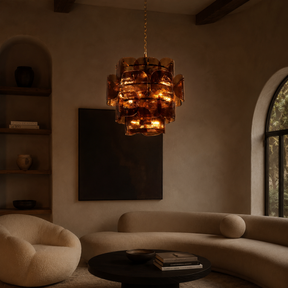 Modern living room with a chandelier, sofa, and round table.