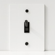 Light switch panel with black rocker switch on a white background