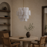Dining room with a round table, chairs, and a modern chandelier.