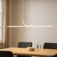 Modern dining area with a pendant light, table, chairs, and a carafe on a neutral background.