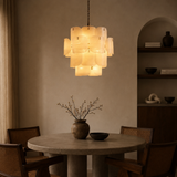 Dining room with a chandelier, table, and chairs in a warm setting.