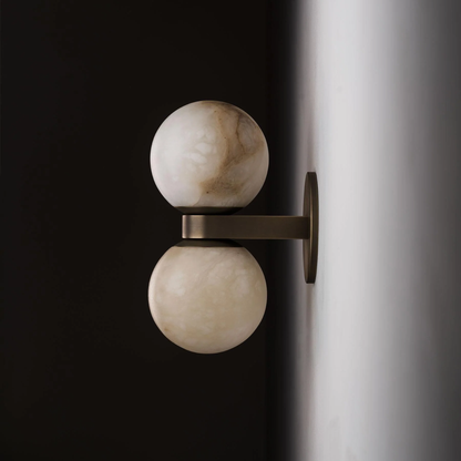 Wall sconce with marble-like spherical design on a dark background