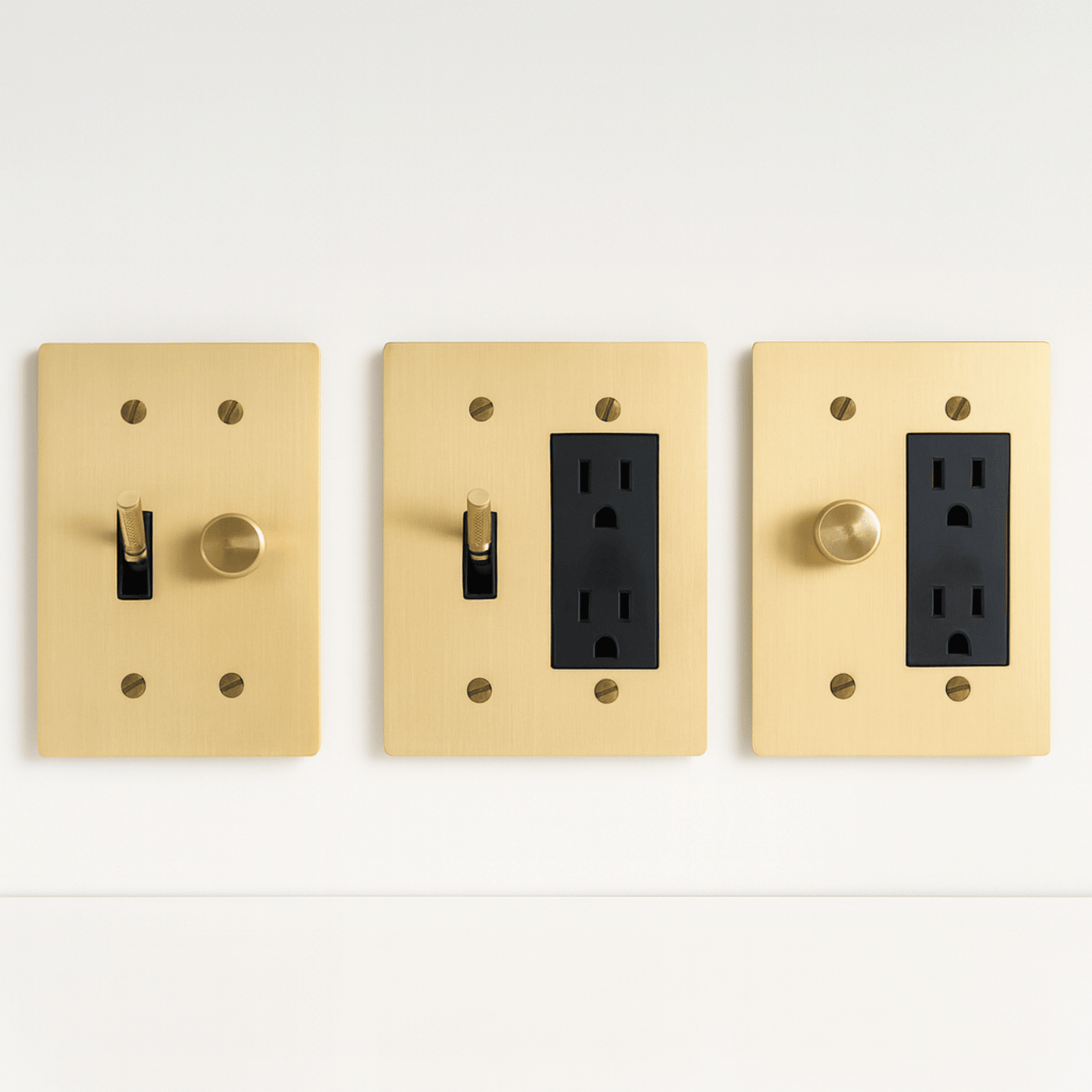 Three gold light switch and outlet covers on a white background
