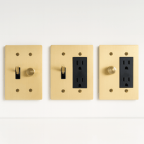 Three gold light switch and outlet covers on a white background