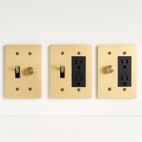 Three gold light switch and outlet covers on a white background