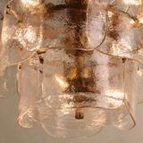 Close-up of a decorative chandelier with glass shades on a neutral background