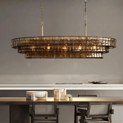 Modern chandelier hanging above a dining table with chairs in a neutral setting