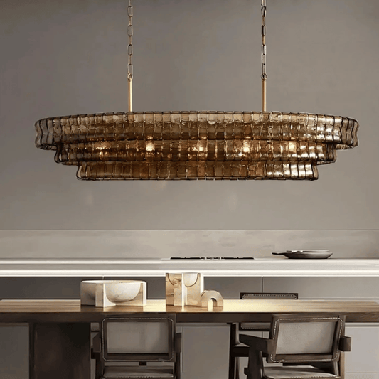 Modern chandelier hanging above a dining table with chairs in a neutral setting
