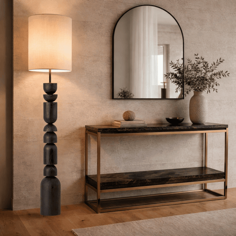 Modern interior with a console table, mirror, and lamp against a beige wall.