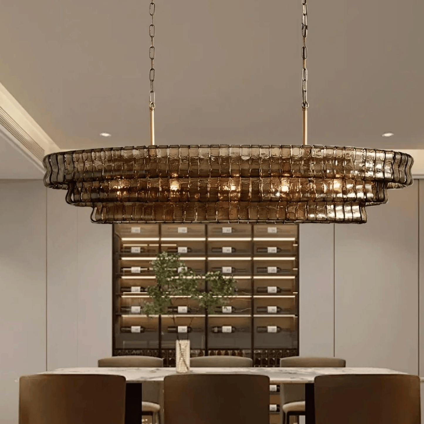 Chandelier hanging above a dining table with a wine cellar in the background
