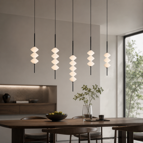 Modern dining room with hanging pendant lights and a wooden table.