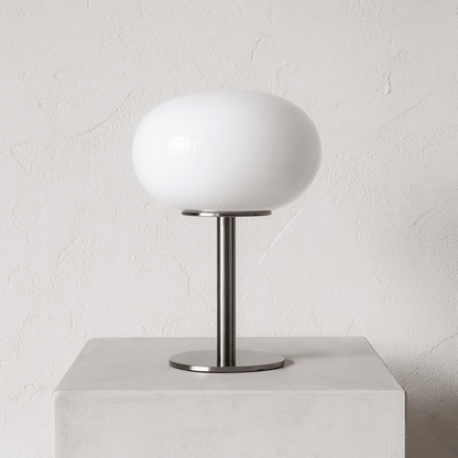 Table lamp with white shade and metal base on a light gray background