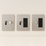 Three light switch and outlet covers on a white wall.