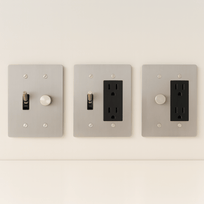 Three light switch and outlet covers on a white wall.