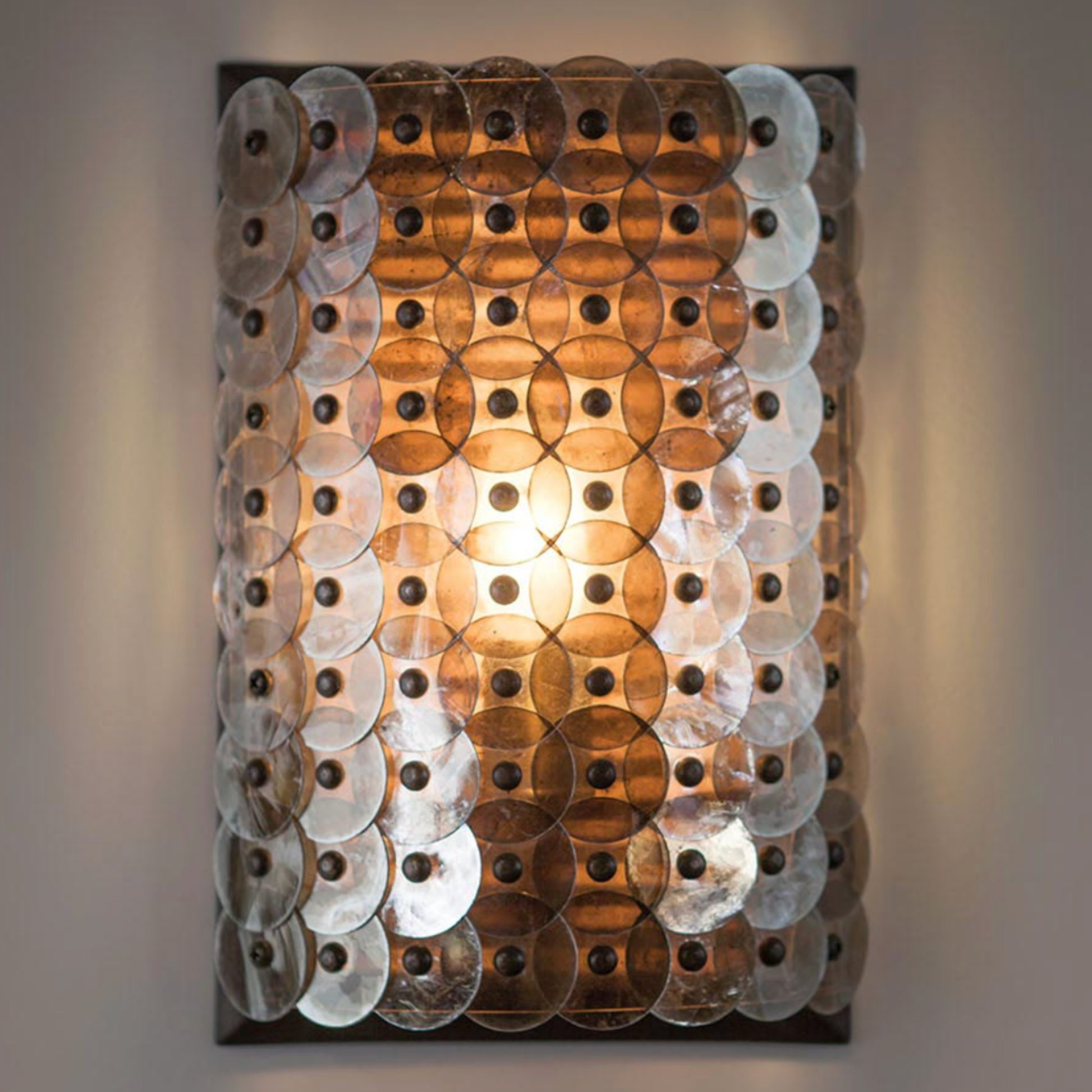 Decorative wall light with circular panels on a gray background