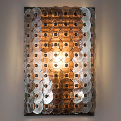 Decorative wall light with circular panels on a gray background
