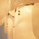 Close-up of a chandelier with textured glass shades and gold accents.