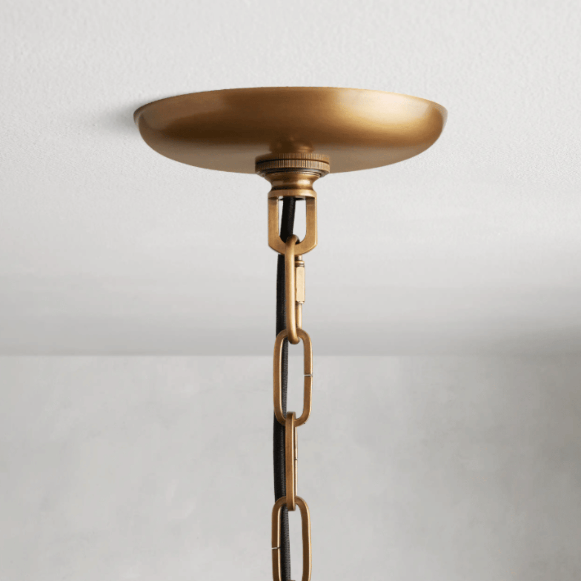 Brass pendant light fixture on a white background