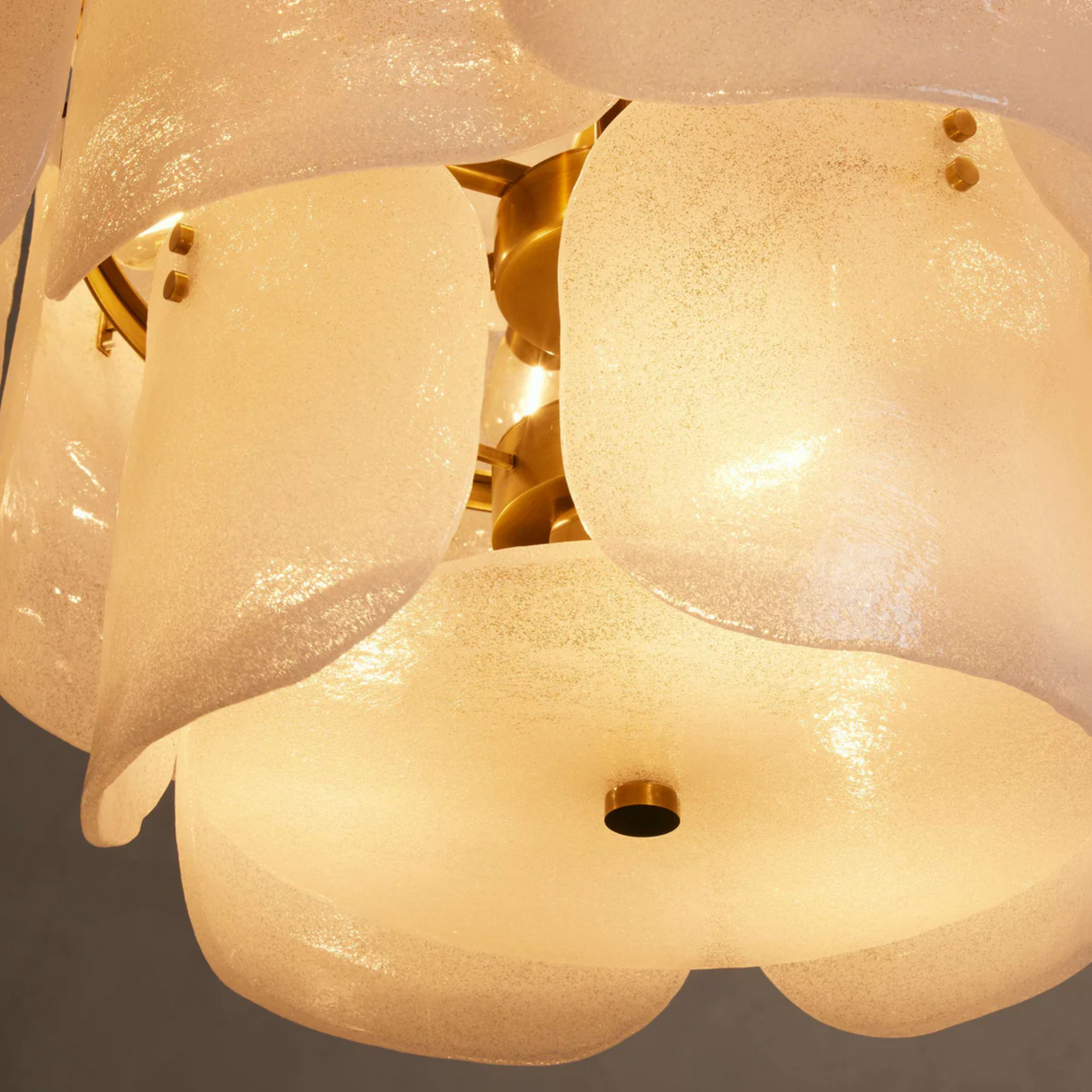 Close-up of a chandelier with glass shades and gold fixtures.