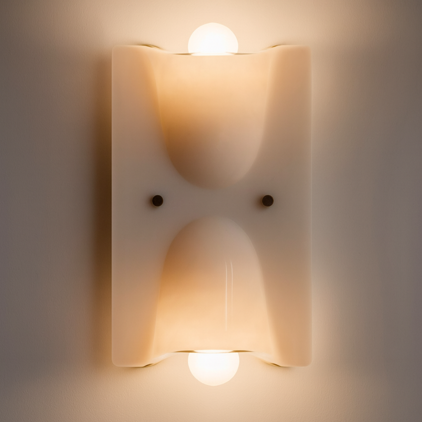 Wall-mounted light fixture with two illuminated bulbs on a neutral background