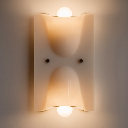 Wall-mounted light fixture with two illuminated bulbs on a neutral background