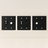 Three black wall plates with different electrical symbols on a beige background