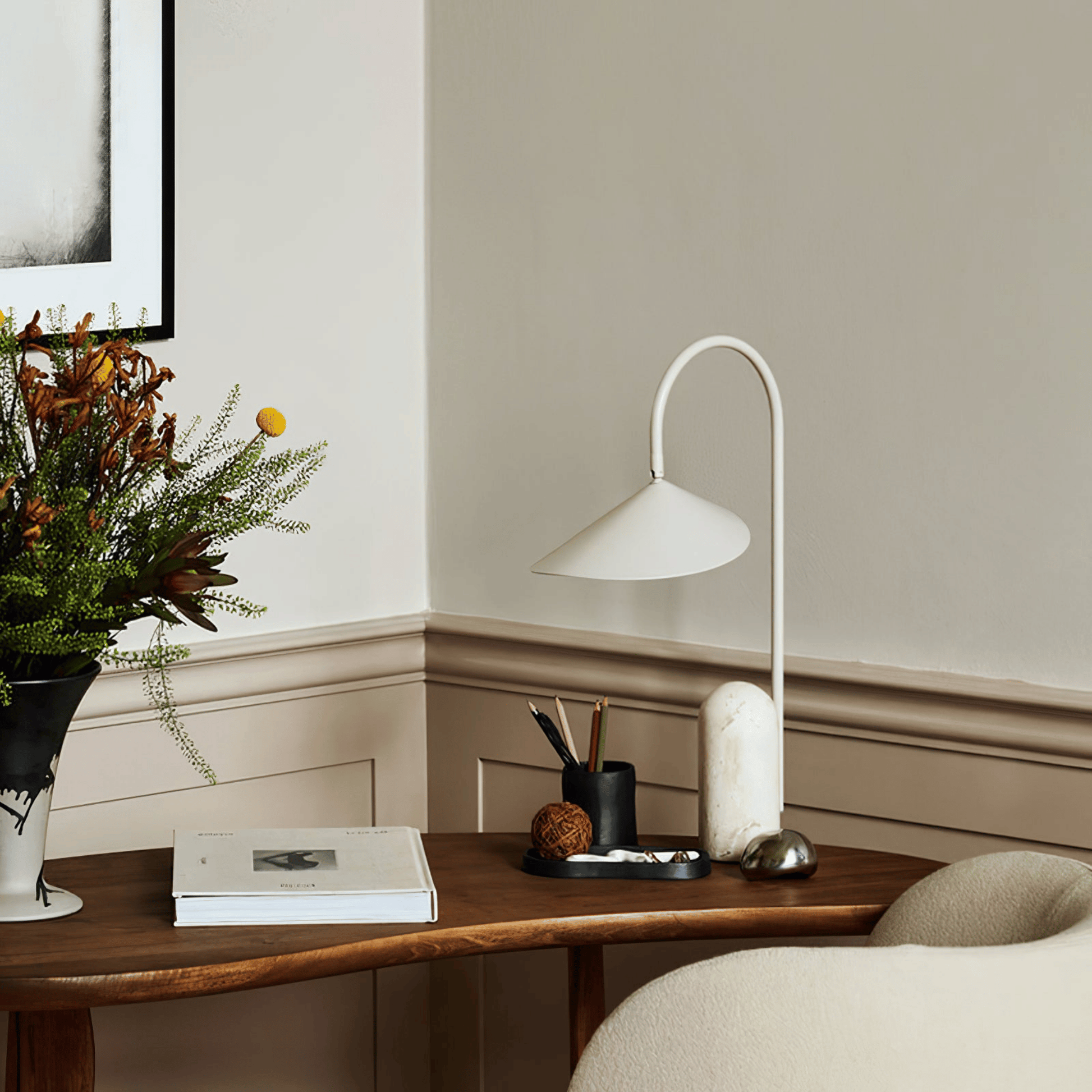 Modern interior with a wooden side table, lamp, and decorative items.