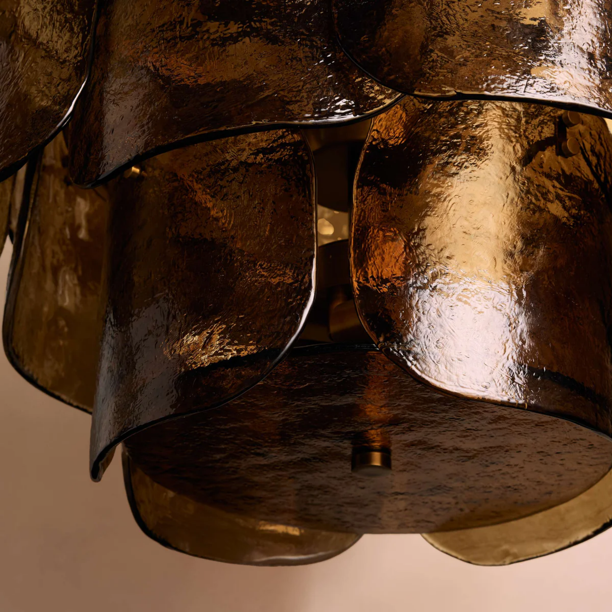 Close-up of a bronze or gold metallic lampshade with a textured surface.