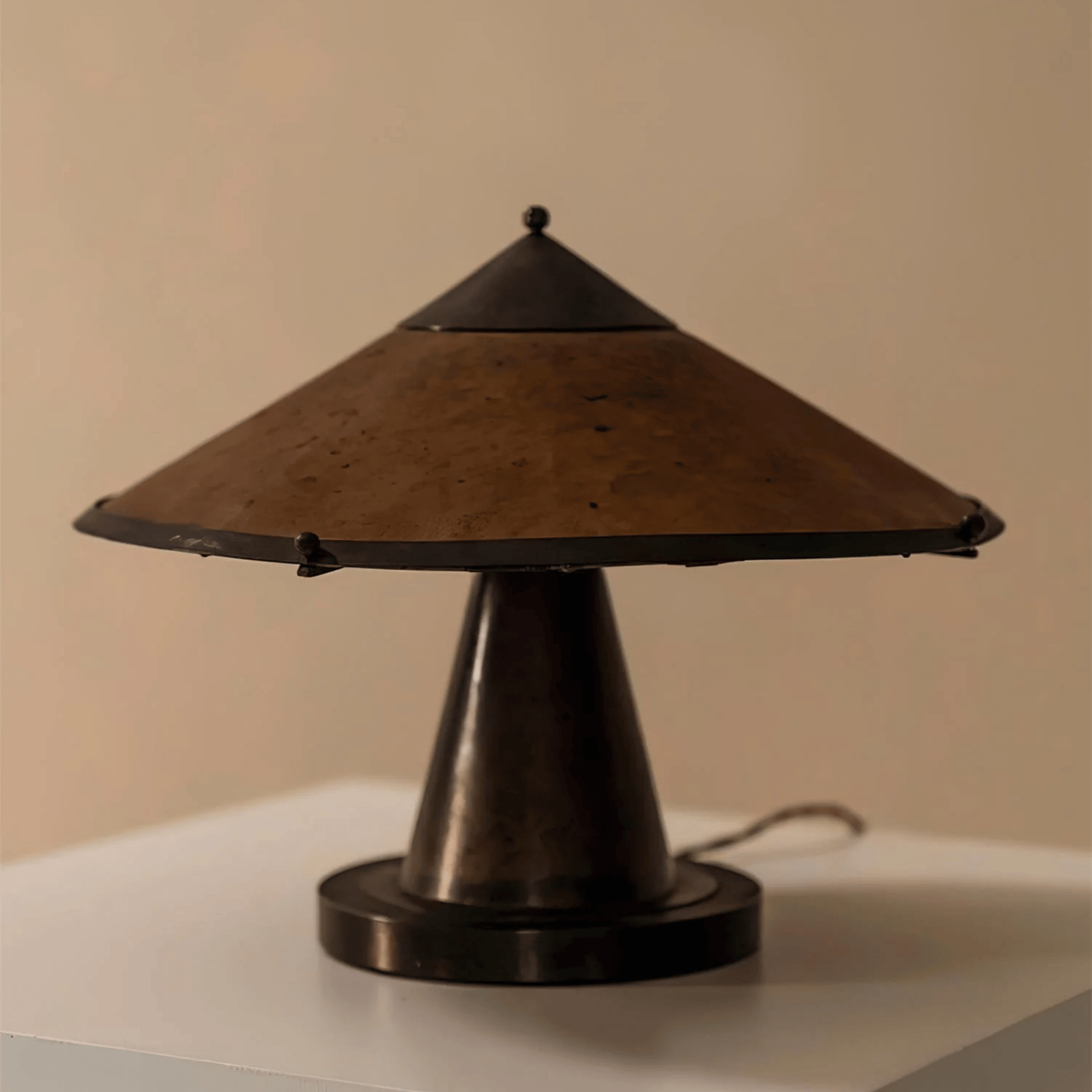 Vintage-style table lamp with brown shade and black base on a neutral background
