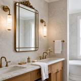 Bathroom with marble countertop, wooden vanity, and large mirror.