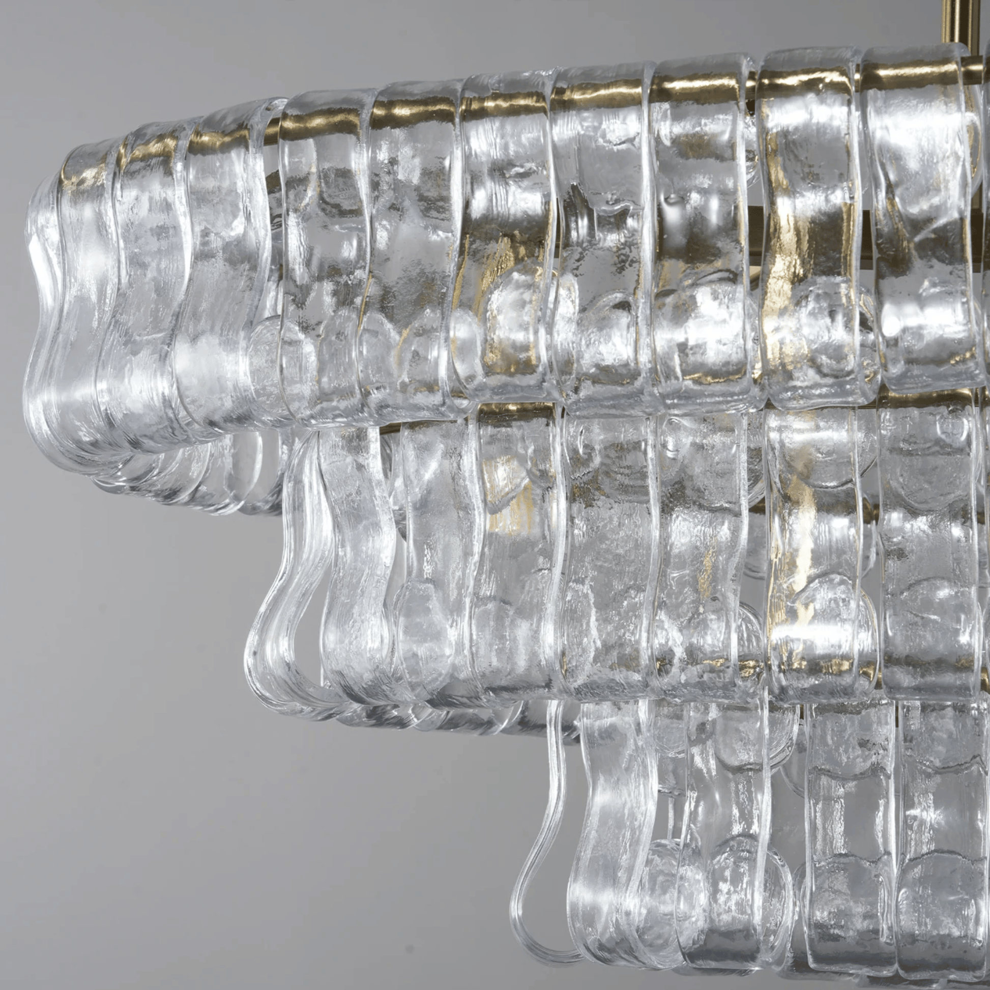 Clear glass chandelier with gold accents on a gray background