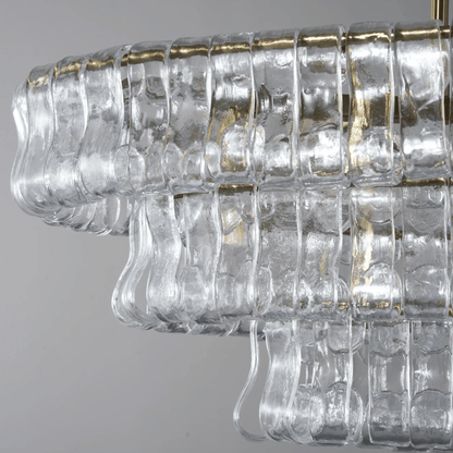 Clear glass chandelier with gold accents on a gray background
