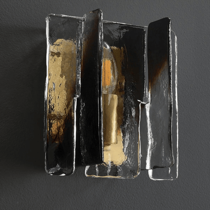 Decorative wall sconce with metallic finish on a dark background