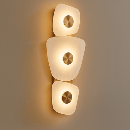 Modern wall sconce with three light fixtures on a neutral background